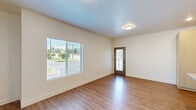 Located at 2525 N Hill Field Rd in Layton, Utah, this well-designed one-bedroom, one-bathroom unit offers a thoughtful layout across a single floor. The open-concept living and kitchen area serves as the heart of the home, featuring warm wood-look luxury vinyl plank flooring, recessed lighting, and a large window with blinds that invites abundant natural light. A private entry door with a sidelight panel adds a welcoming touch.

The kitchen is a standout feature, outfitted with light wood cabinetry, sleek grey quartz countertops, stainless steel appliances including an electric range, built-in microwave, refrigerator, and dishwasher, as well as a matte black faucet over a stainless steel sink. A kitchen island provides additional prep space and casual seating potential.

The bedroom offers a comfortable retreat with plush carpet flooring, neutral walls, and a window that allows for natural light. Adjacent to the bedroom is a generously sized walk-in closet with multiple hanging rods and shelving, providing excellent storage.

The bathroom is finished in a clean, modern style with wood-look flooring, a light wood vanity with quartz countertop, and a full tub-shower combo accented with matte black fixtures. A hallway connects the living areas seamlessly, completing this efficiently designed and contemporary home.