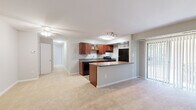 This single-floor residence offers a practical and comfortable layout across three bedrooms, two bathrooms, and a combined kitchen and living area. The open-concept main living space is anchored by a well-appointed kitchen featuring rich cherry wood cabinetry, granite-style countertops, black appliances including a gas range and refrigerator, and a peninsula that provides additional prep and counter space. Track lighting and a ceiling fan illuminate the area, while vertical blinds along a sliding glass door allow natural light to flow into the living room, which is finished with neutral-toned carpet. The bedrooms are carpeted and bathed in natural light through vertical-blind-covered windows. The spacious primary bedroom includes a double closet with bifold doors, offering generous storage. Two additional bedrooms provide flexibility for various living needs, each with their own closet access. The two bathrooms are clean and functional, featuring white tile surrounds with a tub-shower combination. Hallways connect the rooms efficiently throughout the floor plan. With a neutral color palette, durable flooring transitions, and thoughtful storage solutions including three dedicated closets, this residence is designed for comfortable, everyday living.