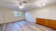 This two-story, 2-bedroom, 2-bathroom home offers a practical and comfortable layout spread across two floors of nearly equal size. The main floor features an open-concept living, dining, and kitchen area. The living room is bright and airy, finished with light wood-look laminate flooring, a ceiling fan with light fixture, and a window that allows natural light to filter in. An elegant chandelier-style light fixture highlights the dining area. The kitchen is well-appointed with warm honey-oak cabinetry, white tile countertops, a tile backsplash, a double sink, and a full suite of white appliances, all set on matching laminate flooring. The main floor also includes hallway access and a staircase leading to the upper level. Upstairs, both bedrooms are carpeted and feature neutral, light-colored walls, providing a calm and restful atmosphere. The spacious primary bedroom includes multiple closets and doors for added storage and accessibility. Two full bathrooms serve the home; one features a tiled tub-shower combination, while the other includes a wood-cabinet vanity with a tile-topped counter and mirror. With four closets total and two hallways, storage and circulation throughout the home are well-considered.