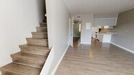 Located at 2400 NW 39th St in Oklahoma City, Oklahoma, this two-story property combines classic character with updated finishes throughout. The main level features an open-concept layout where the living area flows seamlessly into the kitchen. Durable wood-look flooring extends throughout both levels, providing a cohesive and easy-to-maintain surface underfoot. A textured popcorn ceiling adds a period-appropriate detail overhead.

A defining architectural feature of the space is the painted brick accent wall, which appears in both the living area and several of the bedrooms, lending a distinct visual texture and a warm, timeless character. Natural light enters through multiple windows fitted with blinds, brightening each room.

The kitchen is efficiently designed with white cabinetry, light countertops, a brick tile backsplash, and included appliances such as a refrigerator and range. A pass-through counter connects the kitchen to the adjacent living space, enhancing the open feel.

The bedrooms are generously proportioned, each featuring the signature brick accent wall and wood-look flooring. The bathroom is well-appointed with a white vanity, light stone-look countertop, a tub-shower combination, and wood-look flooring. A staircase connects the two floors, completing this well-structured and characterful property.