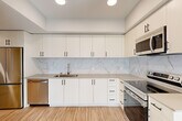 Located at 201 North La Brea Avenue in Inglewood, CA, this well-appointed 2-bedroom, 2-bathroom residence offers a thoughtfully designed single-level layout with a clean, modern aesthetic throughout. Light-toned wood-style flooring flows seamlessly across every room, creating a cohesive and contemporary feel.

The kitchen is a standout feature, showcasing crisp white shaker cabinetry extending to the ceiling for ample storage, a striking marble-style tile backsplash, neutral quartz countertops, and a full suite of stainless steel appliances including a range, microwave, and dishwasher. Recessed lighting illuminates the space efficiently.

The living room is generously proportioned, filled with natural light from large windows and sliding glass doors that open to an outdoor balcony, offering views of the surrounding Inglewood cityscape. Both bedrooms are well-sized with large windows that invite natural light, and each is complemented by a dedicated closet with built-in shelving. The primary bedroom provides a comfortable and private retreat.

The two bathrooms are finished in a clean, modern style, each featuring wood-style flooring, a single-sink vanity with understated cabinetry, a large mirror, and a full tub-shower combination with white tile surround. The overall ambiance of this residence is bright, fresh, and move-in ready.