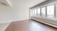 Located on Avenue des Pins Ouest in the heart of Montréal, this well-appointed 2-bedroom, 2-bathroom residence offers a thoughtfully designed single-floor layout. A welcoming hallway with polished light-tile flooring leads into the main living spaces. The open-concept living and dining area is bathed in natural light through large windows that frame sweeping city views, with rich hardwood flooring adding warmth throughout. A balcony extends the living space outdoors, providing additional views of the Montréal skyline.

The contemporary kitchen is a standout feature, showcasing striking wood-grain upper cabinetry, crisp white lower cabinets, dark countertops, stainless steel appliances, a textured tile backsplash, and a central island with pendant lighting — all finished with light large-format tile flooring.

The spacious primary bedroom benefits from generous natural light and city views through a wide window, while the second bedroom features a mirrored sliding closet door. Three closets throughout provide ample storage. The two bathrooms are distinctly designed: one offers a sleek glass-enclosed shower with wood-toned tile walls and hardwood-style flooring, while the second features full-surround tile, a soaking tub, and warm floor tiles. The clean, modern aesthetic is consistent throughout this refined Montréal residence.