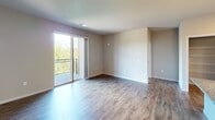 This contemporary 1000 square foot apartment in Verona, Wisconsin offers a blend of comfort and style. The open floor plan maximizes the living space, creating a seamless flow between rooms. The kitchen is a standout feature, boasting dark wood cabinetry, stainless steel appliances, and granite countertops. A central island provides additional prep space and casual dining options.

The living area is bathed in natural light thanks to large windows and sliding glass doors that lead to a private balcony, offering outdoor views and fresh air. The primary bedroom, measuring 160 square feet, is spacious and features plush carpeting and a ceiling fan for comfort.

All three bedrooms are well-proportioned with ample closet space. The two bathrooms are modern and functional, with one featuring a walk-in shower with glass enclosure and wood-look flooring. Throughout the apartment, you'll find a mix of durable wood-look flooring and soft carpeting, creating a cozy yet low-maintenance living environment.

The neutral color palette allows for easy personalization, while recessed lighting and modern fixtures add to the overall contemporary aesthetic. This apartment combines practicality with style, offering a turnkey living solution in a desirable location.