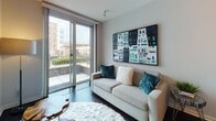 Located at 1600 Harbor Blvd in Weehawken, NJ, this modern single-floor residence offers a well-designed layout with contemporary finishes throughout. The kitchen is outfitted with dark espresso cabinetry, light granite countertops, large-format tile flooring, and a full suite of stainless steel appliances, including a range, microwave, dishwasher, and refrigerator — a highly functional space for cooking and entertaining. The open living area features rich dark hardwood-style flooring and is bathed in natural light from floor-to-ceiling sliding glass doors that lead to a private balcony, offering views of the surrounding Weehawken neighborhood. The bedroom continues the warm hardwood flooring and is generously sized, with access to a private balcony via additional sliding glass doors, allowing for excellent natural light and ventilation. The full bathroom is finished with light tile flooring, a dark vanity with granite countertop, a large mirror, wall-mounted cabinetry, and a shower-tub combination. An in-unit stacked washer and dryer adds everyday convenience. The space maintains a clean, modern aesthetic with neutral tones, consistent high-quality finishes, and a cohesive design language throughout.