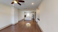 This well-designed two-floor residence offers a clean, modern aesthetic throughout, highlighted by rich hardwood flooring and a neutral color palette that creates a bright and welcoming atmosphere. The open-concept main living area flows seamlessly into the kitchen, which serves as the centerpiece of the home. The kitchen is outfitted with white shaker cabinetry, a large central island featuring a built-in cooktop and sink, quartz countertops, subway tile backsplash, and a full suite of stainless steel appliances including a double wall oven, microwave, dishwasher, and French door refrigerator. Pendant lighting and track lighting combine to illuminate the space beautifully. The living area is accented by a ceiling fan with light, recessed lighting, and a sliding glass door that invites natural light while providing access to an outdoor area. A convenient half bath is located on the main floor. Upstairs, carpeted bedrooms offer a comfortable retreat, each equipped with ceiling fans and ample closet space, including a generously sized walk-in closet with built-in shelving and hanging rods. The bathrooms are finished with clean tilework, glass-enclosed showers, white cabinetry, and modern chrome fixtures, delivering a polished and functional design throughout.