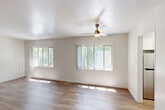 Located at 3500 Edison Street in San Mateo, California, this single-story, one-bedroom, one-bathroom home offers a well-organized and efficient layout across its single floor. The spacious living room is a standout feature, boasting warm hardwood-style flooring, a ceiling fan, and multiple large windows that flood the space with abundant natural light while framing views of surrounding greenery. Crown molding adds a refined touch to the living area's clean, neutral palette. The kitchen is thoughtfully designed with white cabinetry, sleek white countertops, a stainless steel sink, and wood-look flooring, all complemented by a window that brings in additional natural light. The bedroom offers a comfortable, carpeted retreat with a sliding closet, a window with vertical blinds overlooking the outdoors, and soft neutral tones throughout. The bathroom is equipped with a full tub-and-shower combination, white tile surround, chrome fixtures, and a frosted privacy window for natural ventilation. A connecting hallway ties the rooms together seamlessly. The home's consistent use of light tones and natural light throughout creates a bright, welcoming ambiance ideal for comfortable everyday living.