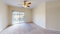 Located at 200 Atrium Way in Columbia, SC, this well-appointed 2-bedroom, 2-bathroom single-floor home offers a comfortable and functional layout. The interior features warm neutral tones and plush carpeting throughout the living and bedroom areas, complemented by tile flooring in the kitchen and laundry room.

The kitchen is thoughtfully designed with gray shaker-style cabinetry, granite countertops, stainless steel appliances, and a pass-through window that connects to the main living area. Crown molding and a ceiling fan accent the spacious living room, which is bathed in natural light from a sliding glass door that opens to a private balcony with outdoor views.

The generously sized primary bedroom features its own ceiling fan and access to a walk-in closet equipped with multi-level wire shelving for ample storage. The second bedroom also includes a ceiling fan, a window for natural light, and its own closet with wire shelving. Both bathrooms are clean and functional, with one featuring a soaking tub and shower combination.

A dedicated laundry room includes wire shelving above washer/dryer hookups and tile flooring, adding everyday convenience. The entry hallway, accented with crown molding, provides a welcoming transition into the home's open living spaces.