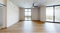 Located at 101 Main St N in Saint Petersburg, FL, this thoughtfully designed 2-bedroom, 3-bathroom residence offers a clean, contemporary aesthetic throughout its well-appointed single-floor layout. Light wood-look flooring flows seamlessly through every room, complementing crisp white walls and exposed concrete ceiling accents that lend an industrial-modern character to the space.

The open kitchen is a standout feature, showcasing light wood cabinetry with matte black hardware, quartz countertops, a classic white subway tile backsplash, and stainless steel appliances. A sliding barn door adds a stylish, functional touch to the living area, which benefits from abundant natural light.

The generously sized primary bedroom features a dramatic floor-to-ceiling window framing panoramic views of the Saint Petersburg skyline and surrounding greenery, along with a ceiling fan and direct access to a spacious walk-in closet with built-in wire shelving. The en-suite primary bathroom offers a dual-sink quartz vanity with warm wood cabinetry, matte black fixtures, framed mirrors, and a large walk-in glass shower with subway tile walls and a built-in bench.

The private balcony provides elevated open-air views of the cityscape. Additional highlights include an in-unit stacked washer and dryer, three full bathrooms, and a dedicated closet, making this a highly functional and refined urban residence.