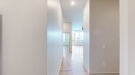 This contemporary one-bedroom, one-bathroom residence at 212 Durham Avenue in Metuchen, NJ offers a thoughtfully designed open floor plan with clean, modern finishes throughout. Light-toned hardwood flooring flows seamlessly across the entire unit, complementing the crisp white walls and creating a bright, airy ambiance.

The combined kitchen and living area serves as the heart of the home. The kitchen is outfitted with sleek white cabinetry extending to the ceiling, stainless steel appliances including a French-door refrigerator, microwave, and range, and a large white quartz peninsula countertop with an undermount sink. Stylish pendant lights hang above the peninsula, adding a modern touch. The open layout allows the kitchen to transition effortlessly into the living area, which benefits from a glass door leading to a private balcony with views of the surrounding neighborhood.

The generously sized primary bedroom features dual windows fitted with horizontal blinds, allowing for ample natural light and outdoor views. A dedicated closet provides convenient storage.

The bathroom is finished in a contemporary style with a gray vanity, white quartz countertop, undermount sink, matte black fixtures and hardware, a large mirror, and clean tile work. The unit also includes a dedicated closet for additional storage needs.