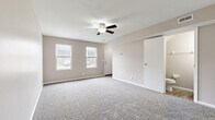 Located in Kettering, Ohio, this two-story, 2-bedroom, 2-bathroom home offers a thoughtfully arranged layout spread across two floors. The main level features a welcoming living room finished with soft carpeting, a ceiling fan, and dual windows that bring in natural light and views of the neighborhood. The galley-style kitchen is well-equipped with white cabinetry, laminate countertops, wood-look flooring, white appliances including a refrigerator and range, and a peninsula that opens toward a staircase. A sliding door in the kitchen leads directly to a private patio with outdoor views. The lower level also includes a bathroom with wood-look flooring and a dark-toned vanity. Upstairs, the generously sized primary bedroom features plush carpeting, a ceiling fan, and a window with tree-lined views. The second bedroom is equally comfortable with carpet and natural light. A full bathroom on the upper level offers a tub-shower combo with a clean, white surround. Two closets provide practical storage throughout the home. Warm neutral tones and consistent finishes create a cohesive, move-in-ready atmosphere throughout this well-organized Kettering residence.