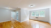 Located at 1059 Pompton Ave in Cedar Grove, NJ, this well-appointed one-bedroom, one-bathroom unit offers a comfortable and functional layout across a single floor. Warm-toned hardwood floors flow throughout the main living areas, lending a bright and cohesive feel to the space.

The living room is generously sized, featuring neutral light-gray walls, a large window that frames views of lush greenery, a wall-mounted air conditioning unit, and baseboard heating. Natural light fills the room, creating an inviting atmosphere. The bedroom is spacious and well-lit, offering two double-door closets for ample storage, hardwood flooring, and a window overlooking the surrounding trees.

The kitchen is efficiently designed with white cabinetry, light countertops, tile flooring, and stainless steel appliances including a gas range and over-the-range microwave. A window above the counter brings in natural light and garden views. The bathroom is clean and bright, finished in white tile with a tub-shower combination and a frosted window for privacy. A dedicated laundry area houses a stacked washer and dryer unit, adding everyday convenience. A connecting hallway ties all rooms together seamlessly, completing this thoughtfully organized home.