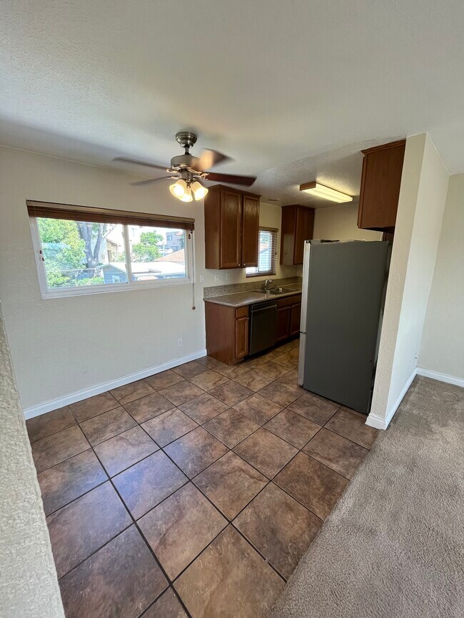 Dining space off living room and into kitchen with tile floors. - 5310 Rex Ave