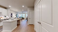 This thoughtfully designed single-floor residence offers a functional and comfortable layout with 1 bedroom, 1 bathroom, and an impressive four closets for exceptional storage. Light wood-tone flooring runs consistently throughout, lending warmth and cohesion to the entire space.

The open-concept kitchen and living area form the heart of the home. The kitchen features white shaker cabinetry, a subway tile backsplash, stainless steel appliances, a central island with bar seating, and recessed lighting overhead. The living room flows naturally from the kitchen, highlighted by large windows with slatted blinds and a glass door that invites abundant natural light and outdoor views. A ceiling fan adds both function and style.

The bedroom is generously sized, with dual windows, a ceiling fan, and direct access to the full bathroom. The bathroom offers a long white vanity with dual sinks, wood-tone flooring, and a shower-tub combination. A spacious walk-in closet with multi-level shelving and hanging rods provides excellent organization potential. Additional closets throughout the unit offer further versatility.

A dedicated laundry area adds everyday convenience, while the neutral gray and white palette throughout creates a clean, modern ambiance that is both inviting and highly functional.