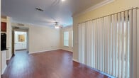 Located at 8787 Sienna Springs Blvd in Missouri City, Texas, this single-story space offers a thoughtfully designed layout with a variety of finishes and functional features throughout.

The main living area is a standout, showcasing rich hardwood-style flooring that extends throughout most of the space. Crown molding frames the ceiling, lending an elevated architectural detail, while a ceiling fan provides both function and style. Natural light filters in through blinds-covered windows, and a full-length vertical blind panel covers a sliding door, offering flexible light control and outdoor access.

The kitchen is well-equipped, featuring warm cherry-toned cabinetry that extends to the ceiling for ample storage, dark granite countertops, a central island with matching countertop, and a full suite of black appliances including a refrigerator, range, microwave, and dishwasher. The hardwood-style flooring continues seamlessly into this space.

The bedrooms are finished with plush carpet and receive natural light through window treatments. The bathroom includes a tiled tub-shower combination with a decorative accent border, complemented by hardwood-style flooring.

A dedicated laundry area with side-by-side washer and dryer units and built-in shelving above adds everyday convenience to this well-rounded space.