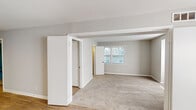 Located at 5939 W Friendly Ave in Greensboro, North Carolina, this single-floor residence offers a well-designed layout with a consistent, modern aesthetic throughout. The interior is finished with a soft, neutral color palette of light and medium grays, creating a calm and cohesive atmosphere across all rooms.

Living areas feature warm wood-look flooring that adds character and visual continuity, while carpeted bedrooms provide a comfortable, quieter feel underfoot. Several rooms benefit from natural light streaming through large windows fitted with blinds, lending an open and airy quality to the space.

The kitchen is thoughtfully appointed with crisp white shaker-style cabinetry, light stone-look countertops, a double stainless steel sink, and stainless steel appliances including a refrigerator, gas range, and microwave. Wood-look flooring extends through the kitchen, tying it seamlessly to adjacent living areas.

The bathroom is clean and functional, featuring a tiled tub-and-shower combination, a white vanity with brushed nickel hardware, and wood-look flooring. Bedrooms are generously proportioned, with at least one featuring a walk-in closet with built-in shelving, and windows that allow ample natural light.

The floor plan, visible in the dollhouse view, reveals a practical and well-connected layout, making this residence an informative and easy-to-navigate space for prospective occupants.