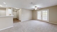 This single-story residence on Cottage Hill Rd in Mobile, Alabama offers a thoughtfully organized layout across two bedrooms, two bathrooms, a kitchen, laundry room, two closets, and a connecting hallway. The living area is carpeted and anchored by a ceiling fan with light fixture, and features French doors that invite natural light and provide outdoor access, contributing to an open, airy feel.

The galley-style kitchen is well-equipped with white shaker cabinetry, light stone countertops, stainless steel appliances including a range, microwave, dishwasher, and refrigerator, and durable wood-look vinyl flooring. A pendant light fixture illuminates the space, which flows into the adjacent dining area.

Both bedrooms feature plush carpet, ceiling fans, and textured ceilings. The generously sized primary bedroom includes a closet, while the secondary bedroom offers a window with natural light and its own closet. Each bathroom is finished consistently with white vanity cabinetry, stone countertops, a tub/shower combination, and wood-look vinyl flooring. The dedicated laundry room includes utility hookups, providing added convenience within the home.