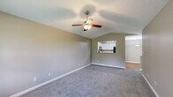 Located at 7111 Vedder Pl in Indianapolis, Indiana, this single-story, 3-bedroom, 2-bathroom home offers a well-organized and functional layout across a comfortable footprint. The living room serves as the heart of the home, featuring vaulted ceilings, a ceiling fan with light fixture, soft carpet flooring, and a pass-through window that connects directly to the kitchen — creating an open, airy feel. The kitchen is equipped with white cabinetry, a dark refrigerator, an electric range, and track lighting overhead, with a breakfast bar providing a casual dining option. Hardwood flooring and a textured ceiling add character to this space. The primary bedroom is generously sized, complete with vaulted ceilings, a ceiling fan, carpet flooring, and a walk-in closet featuring wire shelving. The two additional bedrooms are well-proportioned with carpet, standard closets, and windows that invite natural light. The two bathrooms are clean and functional — one features a walk-in shower with glass door and hardwood floors, while the other includes a full tub/shower combo with white vanity. A dedicated laundry area and a connecting hallway round out the thoughtfully designed floor plan.