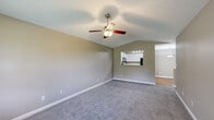 Located at 7111 Vedder Pl in Indianapolis, Indiana, this single-story, 3-bedroom, 2-bathroom home offers a well-organized and functional layout across a comfortable footprint. The living room serves as the heart of the home, featuring vaulted ceilings, a ceiling fan with light fixture, soft carpet flooring, and a pass-through window that connects directly to the kitchen — creating an open, airy feel. The kitchen is equipped with white cabinetry, a dark refrigerator, an electric range, and track lighting overhead, with a breakfast bar providing a casual dining option. Hardwood flooring and a textured ceiling add character to this space. The primary bedroom is generously sized, complete with vaulted ceilings, a ceiling fan, carpet flooring, and a walk-in closet featuring wire shelving. The two additional bedrooms are well-proportioned with carpet, standard closets, and windows that invite natural light. The two bathrooms are clean and functional — one features a walk-in shower with glass door and hardwood floors, while the other includes a full tub/shower combo with white vanity. A dedicated laundry area and a connecting hallway round out the thoughtfully designed floor plan.