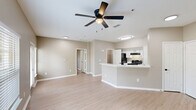 Located at 10532 Klein Rd in Gulfport, Mississippi, this single-floor, one-bedroom, one-bathroom unit offers a thoughtfully designed layout that maximizes functionality and comfort. Light wood-style flooring runs throughout the entire space, complemented by neutral warm-beige walls and crisp white trim, creating a clean and cohesive aesthetic.

The open-concept kitchen and living area serves as the heart of the unit. The kitchen features white shaker-style cabinetry with matte black hardware, marble-look countertops, a double stainless steel sink with a matte black faucet, and black appliances including a range and dishwasher. A peninsula counter provides additional prep space and delineates the kitchen from the living area, which is bathed in natural light from multiple windows and features a ceiling fan with lighting.

The bedroom is a well-proportioned private retreat with a window offering natural light and access to a walk-in closet equipped with wire shelving for ample storage. The bathroom includes a full tub-shower combination, a vanity with marble-look countertops, white cabinetry with matte black hardware, and coordinating fixtures. A dedicated utility room and additional closet round out the practical offerings of this efficiently designed space.