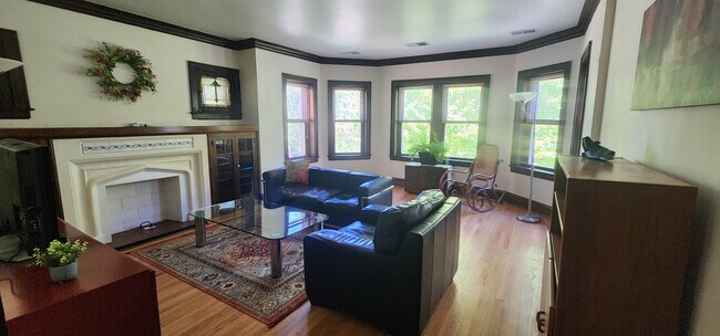 Sala de estar con sofá y sillón de cuero, mecedora antigua, televisor grande, lámparas de pie y aparador. - 2018 Lake St