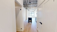 Located at 685 Richmond St in downtown London, Ontario, this 2-bedroom, 1-bathroom unit offers a well-designed, modern living space spread across a single floor. The open-concept layout makes efficient use of space, with a clean, contemporary aesthetic throughout.

The kitchen is equipped with a full suite of stainless steel appliances, including a refrigerator, electric range, over-the-range microwave, and dishwasher. Sleek white cabinetry extends to the ceiling, maximizing storage, while light quartz countertops and a subway tile backsplash complete the modern look. Light hardwood flooring flows throughout the unit, complementing the bright white walls and adding warmth to the space.

Exposed concrete ceiling beams add an industrial character that contrasts attractively with the otherwise crisp, minimalist interior. The bedrooms are well-proportioned, with the primary bedroom offering a comfortable footprint. One bedroom features a large picture window with bold black framing, providing views of the surrounding downtown streetscape and filling the room with natural light.

The bathroom is finished with large-format neutral stone-look tile surrounding a deep soaker tub, creating a clean and relaxing atmosphere. A dedicated closet provides practical storage. The overall ambiance is modern, bright, and urban, well-suited to those seeking a contemporary lifestyle in the heart of London, Ontario.