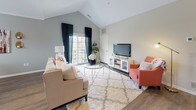 The Cherry floor plan in Canton, Michigan is a thoughtfully designed single-level residence offering two bedrooms and two full bathrooms. The layout flows naturally from the main living areas to the private sleeping quarters, maximizing functionality throughout.

The living room serves as the heart of the home, featuring striking vaulted ceilings that create an open, airy atmosphere. Large windows allow abundant natural light to fill the space, with access to an outdoor balcony enhancing the connection to the outdoors. Wood-style flooring adds warmth and continuity through the living and dining areas.

The kitchen is well-appointed with white shaker-style cabinetry, granite countertops, a subway tile backsplash, and a full suite of stainless steel appliances. A peninsula with an undermount sink provides additional workspace and casual seating.

The adjacent dining area is framed by a large window with outdoor views, creating a bright and inviting setting for meals.

Both bedrooms offer comfortable proportions with plush carpeting. The primary bedroom connects conveniently to the kitchen area. The two bathrooms are finished with granite-topped vanities and white cabinetry, with one featuring a walk-in shower and the other a tub-shower combination.
