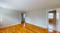 Located at 1221 Magie Ave in Union, New Jersey, this single-floor residence offers a well-maintained and thoughtfully updated living environment. Throughout the main living and bedroom areas, rich hardwood floors gleam with a warm, honey-toned finish, complemented by neutral gray walls and clean white trim that create a bright and inviting atmosphere. Multiple windows allow natural light to fill each room, while classic cast-iron radiators provide efficient heating throughout the space.

The kitchen stands out as a key highlight, featuring rich cherry-toned shaker-style cabinetry, striking granite countertops with a gray and white veining pattern, a stainless steel undermount sink, and a light subway tile backsplash. Stainless steel appliances — including a gas range, dishwasher, and over-the-range microwave — complete this functional and stylish culinary space. Light ceramic tile flooring grounds the kitchen with a clean, durable finish.

The bathroom is equally well-appointed, showcasing a granite-topped vanity with a dark wood base, a full tub-and-shower combination with white tile surround accented by a decorative mosaic border, a round mirror, and tile flooring. A ceiling fan with integrated lighting adds comfort to one of the bedrooms, which also benefits from direct outdoor views. The overall layout, as seen from the dollhouse view, is compact yet efficient, offering a cohesive and comfortable single-level living experience.