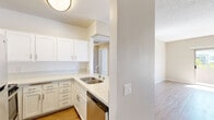 Located at 8601 Glenoaks Blvd in Los Angeles, CA, this one-bedroom, one-bathroom residence offers a well-organized single-floor layout that makes efficient use of its space. The living room is bright and open, featuring light wood-style flooring, neutral beige walls, a textured ceiling, and a sliding glass door that invites natural light and provides access to an outdoor area with pleasant views of the surrounding greenery. The kitchen is thoughtfully designed with white shaker-style cabinetry, light stone countertops, a stainless steel undermount sink, and a full suite of stainless steel appliances including a refrigerator, range, microwave, and dishwasher. A structural column separates the kitchen from the living area, adding architectural character to the space. The generously sized primary bedroom is carpeted for comfort and features a large window with vertical blinds that allow ample natural light, along with a dedicated closet for storage. The bathroom is clean and functional, outfitted with a white vanity with stone countertop, a mirrored medicine cabinet, wood-style flooring, and a shower-tub combination. The unit's consistent neutral color palette and modern finishes create a cohesive and inviting atmosphere throughout.
