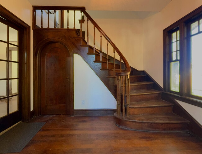 Vintage, craftsmen-built entry stairway curves up to second story living space (separate apartment). - 3448 SW Canby St
