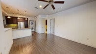 Located in Katy, Texas, this one-bedroom, one-bathroom two-story residence offers a thoughtfully designed layout that maximizes every square foot. The main living level features rich hardwood-style flooring throughout the open-concept living and kitchen areas, complemented by crown molding, recessed lighting, and a ceiling fan that enhance the bright, airy atmosphere.

The kitchen is a standout, boasting dark espresso cabinetry, granite countertops, a peninsula with a double sink, and a full suite of stainless steel appliances including a range, microwave, and refrigerator. Pendant lighting and under-cabinet illumination add a polished touch. A stacked washer and dryer unit is conveniently integrated into the space.

The bedroom is carpeted for comfort and features a ceiling fan, dual entry doors, and French doors that open to a private balcony with neighborhood views. A spacious walk-in closet with built-in shelving and dual hanging rods provides generous storage.

The bathroom is finished with tile flooring, a granite-topped dark wood vanity with ample cabinetry, a tub-shower combination with tile surround, and grab bars for added convenience. The overall design is cohesive, functional, and move-in ready.