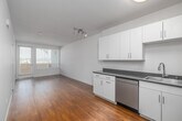 Located at 417 Centinela Ave in Inglewood, CA, this well-designed one-bedroom, one-bathroom unit offers a clean, modern aesthetic throughout. Warm hardwood flooring flows continuously across the entire space, complementing the bright white walls and creating a cohesive, welcoming atmosphere.

The open-concept kitchen and living area serves as the heart of the unit. The kitchen is equipped with stainless steel appliances — including a refrigerator, range, microwave, and dishwasher — alongside white shaker-style cabinetry, dark countertops, and a sink. Track lighting and flush-mount ceiling fixtures ensure the area is well-lit.

The bedroom is a comfortable, well-proportioned retreat featuring a large window that invites natural light and provides outdoor views. Multiple closets throughout the unit offer generous storage options. A hallway connects the main living spaces to the bathroom, which features a full tub-shower combination with clean white tile surround.

Additional highlights include a private patio accessible from the living area through a glazed door with sidelight, an in-unit laundry area, and a practical layout that maximizes every square foot. The overall design is clean and contemporary, making this an efficient and livable space in a convenient Inglewood location.