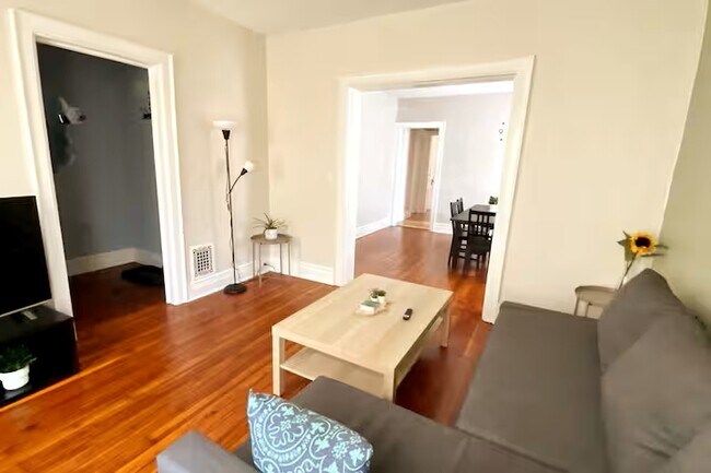 Amplia sala de estar con sofá cama y televisor de 55 pulgadas. - 203 W Tupper St