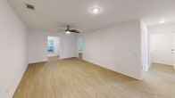 Located at 2109 Oglethorpe Circle in Pooler, Georgia, this 2-bedroom, 2-bathroom single-story home offers a clean, modern aesthetic throughout. Light wood-tone flooring flows seamlessly across all living areas, complementing the crisp white walls and creating a bright, cohesive feel.

The open living area is well-proportioned and airy, featuring ceiling fans with integrated lighting and windows that invite natural light and views of the surrounding greenery. The layout connects the living space directly to the kitchen, enhancing the sense of openness.

The kitchen is fully updated with white shaker-style cabinetry, white quartz countertops, a classic subway tile backsplash, and a full suite of stainless steel appliances including a range, over-the-range microwave, and dishwasher. A window above the sink provides additional natural light.

The primary bedroom is a comfortable, well-sized retreat featuring dual windows with views of lush outdoor foliage and ample wall space. The second bedroom is equally bright and clean, with its own window and closet access.

Both bathrooms are finished in a consistent white palette. The primary bath features a walk-in shower with built-in shelving and brushed nickel fixtures, while the second bath offers a full soaking tub and shower combination. Both include vanities with white cabinetry and mirrors.