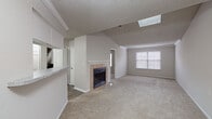 This two-story home is designed with a practical and comfortable layout spread across two levels. The main level welcomes you through a front entry framed by windows dressed with blinds, filling the space with natural light. Crown molding and a textured ceiling add architectural detail to the living area, which centers around a tile-surround fireplace with a white mantel — a notable focal point of the room. Carpet flooring extends throughout the main living and dining areas, contributing to a warm, inviting atmosphere.

The kitchen features white cabinetry, granite-look countertops, a tile backsplash, and stainless steel appliances including a range and over-the-range microwave. Wood-look flooring runs through the kitchen, and a conveniently located laundry area with a washer and dryer is accessible directly off the kitchen. A full bathroom on this level includes a granite-top vanity with white cabinetry, a tub-shower combo, and wood-look flooring.

The staircase, accented with crown molding, leads to the upper level, where additional bedrooms are fitted with carpet flooring and ceiling fans with light fixtures. A second full bathroom mirrors the first, with a granite vanity and tub-shower combo. Throughout both floors, the neutral color palette creates a cohesive and move-in-ready environment.