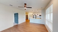 This well-appointed 3-bedroom, 2-bathroom home in Opelika, Alabama offers a thoughtfully designed single-floor layout with modern finishes throughout. The open-concept living and kitchen area serves as the heart of the home, featuring warm hardwood-style flooring, recessed lighting, and a ceiling fan. The kitchen is outfitted with stainless steel appliances, including a refrigerator, range, and microwave, complemented by sleek white upper cabinetry, wood-toned lower cabinets, a subway tile backsplash, and a peninsula with pendant lighting — ideal for both cooking and casual dining. Natural light filters in through large windows, offering pleasant outdoor views. Each of the three bedrooms is carpeted and equipped with a ceiling fan, providing a comfortable retreat. The spacious primary bedroom enjoys its own natural light through large windows. The home includes six closets, several of which feature wire shelving systems for ample storage. Both bathrooms are finished with clean, contemporary fixtures; one features a full tub-shower combination with marble-style tile surround and a wood-tone vanity with black hardware accents. A dedicated laundry room houses a full-size side-by-side washer and dryer. The overall aesthetic is clean, modern, and move-in ready.