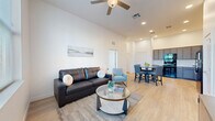 Located at 3525 N Peoria Ave in Tulsa, Oklahoma, this well-designed 2-bedroom, 2-bathroom unit offers a thoughtfully planned single-level layout that maximizes functionality and comfort. The open-concept living, dining, and kitchen area serves as the heart of the home, with light wood-style flooring flowing throughout and crisp white walls that enhance the sense of openness. A ceiling fan and recessed lighting illuminate the living space, which benefits from large windows that bring in abundant natural light and outdoor views. The kitchen is well-appointed with grey shaker-style cabinetry, light stone countertops, and a full suite of black appliances including a refrigerator, range, microwave, and dishwasher. The adjacent dining area provides space for a full table and chairs. Both bedrooms are generously sized, featuring large windows that fill the rooms with natural light. The primary bedroom offers a comfortable footprint with ample closet space. The bathrooms are finished with matching grey cabinetry, white countertops, and wood-style flooring. Additional highlights include four closets, an in-unit laundry area, and a clean, modern aesthetic throughout that makes this a practical and inviting living space.
