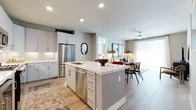This thoughtfully designed 2-bedroom, 2-bathroom residence offers a comfortable and functional single-floor layout. The open-concept kitchen, dining, and living area serves as the heart of the home, highlighted by light hardwood flooring that flows seamlessly throughout. The kitchen is outfitted with stainless steel appliances — including a gas range, built-in microwave, and French door refrigerator — complemented by crisp white quartz countertops, a subway tile backsplash, gray shaker cabinetry, and a spacious island with bar seating. The living area is bright and airy, with large sliding glass doors that invite abundant natural light. Both bedrooms feature plush carpeting and dedicated closets. The primary bedroom is a comfortable retreat with large windows and room for a full bedroom suite. The second bedroom offers similar warmth and versatility. Two full bathrooms include extended vanities with under-mount sinks, tile flooring, and tub-shower combinations. Ceiling fans and recessed lighting are featured throughout, adding to the clean, modern aesthetic of this well-planned residence.