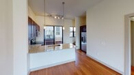This contemporary multi-level residence in Minneapolis's Whittier neighborhood offers a thoughtfully designed layout spread across three floors. The open-concept living area showcases warm hardwood flooring, track lighting, and a ceiling fan, with large windows and glass doors that flood the space with natural light and provide views of the surrounding neighborhood.

The kitchen is a standout feature, equipped with rich dark wood cabinetry, granite countertops, a tile backsplash, and stainless steel appliances including a range, microwave, and refrigerator. A peninsula with pendant lighting adds both functionality and style, while a sliding glass door opens directly to a private balcony.

The bedrooms are carpeted for comfort and each features generous windows that bring in ample daylight. The primary bedroom includes access to a walk-in closet, while additional bedrooms offer views of the neighboring architecture. The bathrooms are well-appointed, with one featuring a dual-sink vanity with dark wood cabinetry, framed mirrors, and a combination tub and shower with tile surround. A second bathroom provides a single vanity, tile flooring, and a bright window.

Upper-level living spaces continue the hardwood flooring, complemented by clerestory windows and balcony access, creating a bright and airy atmosphere throughout this well-finished urban residence.