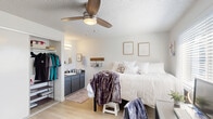 Located at 1863 Kincaid St in Eugene, Oregon, this private bedroom offers a well-organized and functional living space designed to accommodate both rest and study. The room features light wood-style flooring throughout, crisp white walls, and a textured ceiling with a ceiling fan and integrated light fixture, helping to keep the space comfortable year-round.

A large sliding-door closet provides ample storage with a hanging rod, upper shelf, and space for a freestanding organizer below. Adjacent to the closet, a built-in vanity area includes a sink, dark cabinetry with a granite-style countertop, and a mirror with overhead lighting — a convenient in-room amenity. A wall-mounted shelf adds additional storage near the vanity area.

A sizable window fitted with horizontal blinds allows natural light to fill the room, creating a bright and welcoming atmosphere. The layout comfortably accommodates a full-sized bed, a dedicated desk and workspace, and a tall dresser, making efficient use of the available space.

The room's clean, neutral aesthetic and practical features make it a well-suited option for students seeking private accommodations in close proximity to the University of Oregon campus.
