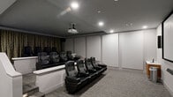 Located at 3000 Valley Forge Circle in King of Prussia, PA, this purpose-built screening room delivers an immersive, cinema-quality experience within a compact, single-floor layout. The space is designed with two tiers of seating, each row elevated above the next to ensure unobstructed sightlines throughout. Both levels are outfitted with plush, black leather recliner-style chairs equipped with built-in cup holders, closely mirroring the comfort and functionality of a commercial movie theater.

A ceiling-mounted projector serves as the primary display source, projecting onto a large, wall-mounted projection screen positioned at the front of the room. Flanking the screen are vertical column speakers, contributing to a well-rounded surround sound setup. A soundbar is also mounted below the screen for additional audio reinforcement. Decorative floor-to-ceiling drape curtains line one wall, adding acoustic dampening and a classic cinematic aesthetic.

The room features a dark, coffered ceiling with recessed lighting that allows precise control over the viewing environment. Step lighting along the tiered platform enhances safety and ambiance. The neutral gray carpeting, light gray walls, and dark ceiling create a cohesive, focused atmosphere ideal for film screenings, presentations, or private events.