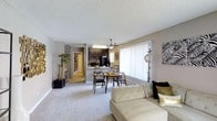 This thoughtfully renovated 1-bedroom, 1-bathroom unit offers a well-designed single-floor layout that maximizes comfort and functionality. The open-concept living and dining area is bright and welcoming, anchored by large windows dressed with vertical blinds that invite abundant natural light into the space. Plush wall-to-wall carpeting runs throughout the main living areas, adding warmth underfoot.

The dining area is conveniently positioned adjacent to the kitchen, creating a seamless flow for everyday living and entertaining. The kitchen features dark cabinetry, a ceiling-mounted light fixture, and standard appliances including a refrigerator and range, with a pass-through counter that connects the kitchen to the dining space. A ceiling fan serves the main living area, providing year-round comfort.

Neutral wall tones and a textured ceiling complement the updated finishes found throughout the unit. A hallway leads from the main living area to the bedroom and bathroom, maintaining a clear sense of separation between the private and shared spaces. The bedroom features continued carpeting and access to natural light. The overall ambiance is clean, modern, and move-in ready, reflecting the care taken during the renovation process.