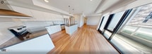 This contemporary 830 sq ft, 2-bedroom, 2-bathroom condo at 1325 Riverbend Rd offers modern design throughout. The open-concept kitchen and living area is anchored by a sleek island with dark countertops, crisp white cabinetry, subway tile backsplash, stainless steel appliances including a wall-mount range hood, and globe pendant lighting — all set over warm hardwood flooring that flows throughout the unit. The living room features large sliding glass doors that flood the space with natural light and open to a balcony with outdoor views. Both bedrooms are well-proportioned, with the primary at 100 sq ft, and feature bright windows with exterior views and neutral tones. The two bathrooms are finished with large-format marble-look tile wall surrounds and brushed gold fixtures — one featuring a soaking tub with a slide bar shower, the other a glass-enclosed walk-in shower. Additional spaces include a hallway and closet. The unit's clean palette of neutral walls, hardwood floors, and modern fixtures creates a cohesive, move-in-ready aesthetic throughout.