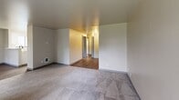 Located at 908 76th St E in Tacoma, WA, this 2-bedroom, 3-bathroom residence offers a well-organized single-floor layout designed for comfortable everyday living. The kitchen is a standout feature, equipped with white shaker cabinetry, stone-look countertops, stainless steel appliances including a refrigerator and range, a double-basin sink with a matte black faucet, and wood-look luxury vinyl flooring. A peninsula counter provides a convenient transition between the kitchen and the adjacent living area. The living room is bright and inviting, featuring plush carpeting, a wall-mounted electric fireplace, and a large window that allows natural light to fill the space. Both bedrooms are carpeted and include windows that bring in natural light, with the primary bedroom offering a generous footprint. The three bathrooms are finished with clean, neutral tones, white vanity cabinetry, and light countertops, with matte black hardware accents adding a modern touch. Throughout the unit, neutral warm-beige walls and consistent flooring transitions create a cohesive and move-in-ready aesthetic. The overall ambiance is clean, functional, and understated, well-suited for those seeking a practical and comfortable home in Tacoma.