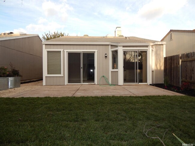 Backyard, kitchen sliding doors on right, master bedroom sliding doors on left. Rose garden on left not pictured. - 5908 Meadowdale Dr