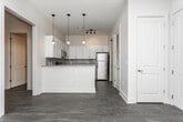 Located at 2891 Lewis St NW in Kennesaw, Georgia, this single-floor residence offers a well-designed layout with modern finishes throughout. The kitchen serves as a central highlight, showcasing crisp white shaker cabinetry, granite countertops, a subway tile backsplash, and a full suite of stainless steel appliances including a range, microwave, refrigerator, and dishwasher. A peninsula with a granite top provides additional workspace and casual seating, while dark hardwood-style flooring anchors the space with warmth and contrast. An in-unit laundry area is conveniently accessible from the kitchen. The bedrooms are finished with plush neutral carpet, offering a comfortable and quiet retreat. Each bedroom features panel-style doors, natural light from windows with blinds, and generous closet space, including a walk-in closet in one of the rooms. The bathrooms are appointed with white cabinetry, granite-topped vanities, and dark wood-style flooring that ties in with the rest of the home. One bathroom includes a tub-shower combination, while another features a walk-in shower. Clean white walls and consistent trim work throughout the unit contribute to a cohesive, move-in-ready aesthetic that is both functional and contemporary.