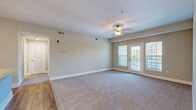 Located at 1000 Revere Place in Spring Hill, Tennessee, this single-floor, one-bedroom, one-bathroom residence offers a well-considered layout across a comfortable footprint. The living room serves as the heart of the home, featuring plush carpet, a ceiling fan with light fixture, and French doors flanked by windows that invite an abundance of natural light and provide access to an outdoor area. The neutral, warm-toned walls throughout create a bright and welcoming ambiance.

The kitchen is thoughtfully appointed with dark espresso cabinetry, granite countertops, a classic subway tile backsplash, and a full suite of stainless steel appliances including a refrigerator, range, microwave, and dishwasher. Wood-look flooring in the kitchen adds a warm contrast to the rest of the home.

The generously sized bedroom features soft carpeting, a ceiling fan, and a natural light window with outdoor views. It connects to a spacious walk-in closet outfitted with multi-level wire shelving for ample storage. The bathroom offers a dark-toned vanity with a light countertop, tile flooring, and a clean, functional design. A dedicated laundry room houses a full-size top-loading washer and dryer, completing this practical and comfortable home.