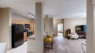 Located at 14111 Vance Jackson Rd in San Antonio, Texas, this single-floor residence offers a thoughtfully designed layout with 2 bedrooms and 2 bathrooms. The living room features light wood-style flooring, a ceiling fan, and sliding glass doors that invite natural light, creating a bright and welcoming atmosphere. The galley-style kitchen is equipped with black stainless appliances, warm wood cabinetry, granite countertops, and track lighting overhead. A breakfast bar with seating connects the kitchen to the adjacent dining area, which offers a cozy space accented by neutral tones and tasteful wall décor. The primary bedroom is generously sized, with plush carpeting, a ceiling fan, and windows with blinds that allow for adjustable natural light. The second bedroom mirrors this comfortable aesthetic. Both bathrooms feature tile flooring, warm wood vanities with granite countertops, and tub-shower combinations. A dedicated utility room and closet add practical storage and convenience. Throughout the residence, a consistent warm beige color palette creates a cohesive and inviting ambiance, complemented by wood-style flooring in the main living areas and soft carpeting in the bedrooms.