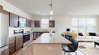Located at 215 3rd St in Wausau, Wisconsin, this well-appointed 2-bedroom, 2-bathroom residence offers a thoughtfully designed open-concept layout across a single floor. The kitchen is a standout feature, showcasing rich dark cabinetry, gleaming granite countertops, a large center island with pendant lighting, and a full suite of stainless steel appliances including a refrigerator, range, microwave, and dishwasher. The kitchen flows seamlessly into the living area, which is bathed in natural light from multiple windows. Wood-look plank flooring extends throughout the main living spaces, adding warmth and continuity to the design. The primary bedroom offers generous proportions with plush carpeting, natural light from a large window, and ample closet space. The second bedroom is equally well-sized. Both bathrooms are clean and functional, with one featuring a walk-in shower with wood-look tile flooring. A dedicated in-unit laundry room houses a full-size front-loading washer and dryer. Two closets provide additional storage throughout the residence. Neutral tones and modern finishes create a cohesive, contemporary ambiance throughout this move-in-ready Wausau home.