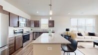 Located at 215 3rd St in Wausau, Wisconsin, this well-appointed 2-bedroom, 2-bathroom residence offers a thoughtfully designed open-concept layout across a single floor. The kitchen is a standout feature, showcasing rich dark cabinetry, gleaming granite countertops, a large center island with pendant lighting, and a full suite of stainless steel appliances including a refrigerator, range, microwave, and dishwasher. The kitchen flows seamlessly into the living area, which is bathed in natural light from multiple windows. Wood-look plank flooring extends throughout the main living spaces, adding warmth and continuity to the design. The primary bedroom offers generous proportions with plush carpeting, natural light from a large window, and ample closet space. The second bedroom is equally well-sized. Both bathrooms are clean and functional, with one featuring a walk-in shower with wood-look tile flooring. A dedicated in-unit laundry room houses a full-size front-loading washer and dryer. Two closets provide additional storage throughout the residence. Neutral tones and modern finishes create a cohesive, contemporary ambiance throughout this move-in-ready Wausau home.