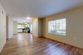 Located at Gregory's Landing in Marysville, WA, this well-appointed 2-bedroom, 2-bathroom single-floor home offers a practical and comfortable layout designed for everyday living. The open-concept living and kitchen area forms the heart of the home, where warm wood-look flooring flows throughout and large windows invite generous natural light. The kitchen is thoughtfully designed with white cabinetry, dark countertops, stainless steel appliances including a refrigerator, range, microwave, and dishwasher, plus a pendant light fixture that adds a clean, modern touch.

The living area is bright and spacious, with neutral wall tones and multiple windows offering pleasant outdoor views. Both bedrooms are carpeted for comfort, with the primary bedroom offering a notably generous footprint and access to a walk-in closet with built-in wire shelving. The second bedroom also features a closet with wire shelving and a large window. Both bathrooms are clean and functional, with one featuring a full tub-shower combination and wood-look flooring. A dedicated laundry area adds everyday convenience. The home's cohesive neutral palette and single-level layout make it an accessible and move-in-ready residence.
